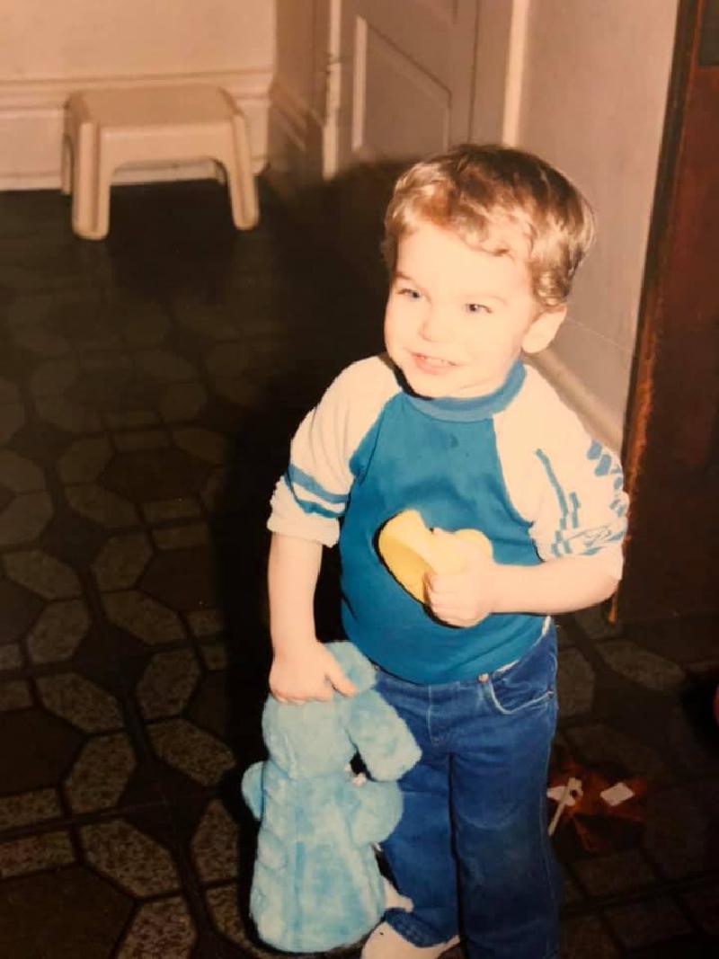 It's a picture of toddle me, at 3 years old holding a stuffed Eeyore from Winnie the Pooh